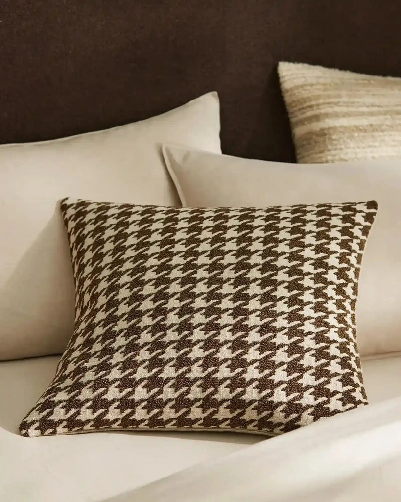 Houndstooth brown and cream cushion in a soft boucle, with contrasting plain cream cushions