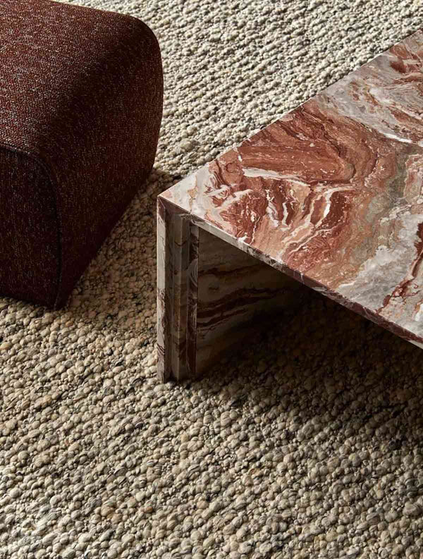 A textural wool blend boucle style rug by Globe West and Soren Liv NZ in shades of light grey and brown, situated in a stylish living room. 
