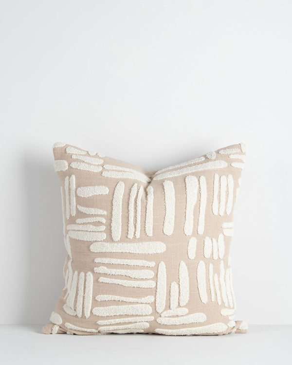 A textural cushion in shades of warm beige and white, with tufted embroidery adding interest to the piece. By Baya