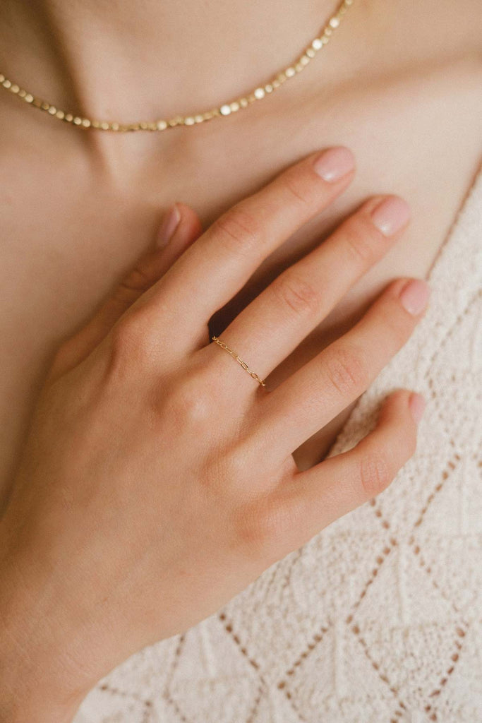 A woman's hand wearing an intricately crafted thin chain ring, by Zoaje