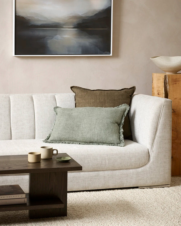 Sage green lumbar cushion with soft fringed detail surround, on a couch in a contemporary nz home
