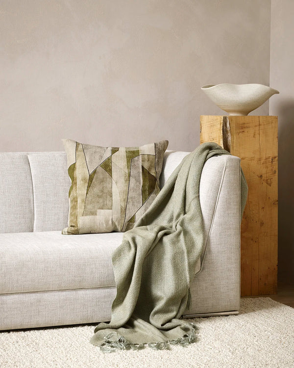Baya sage green throw blanket draped over a couch in a contemporary living room