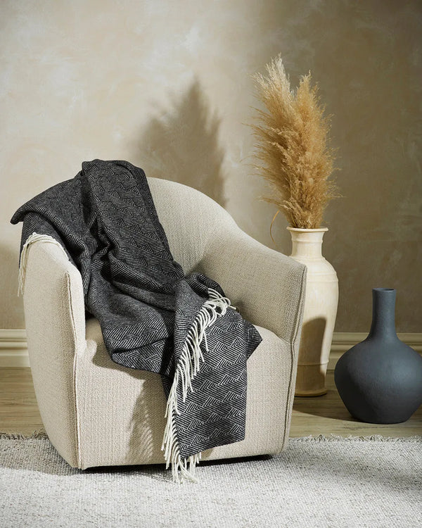 Baya Lana wool throw blanket draped over a chair in a contemporary lounge room