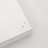 Two tiny delicate pearl stud earrings viewed from above. 
