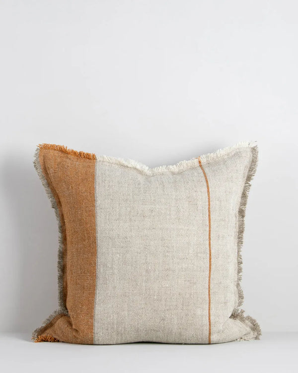 A natural linen cushion with a rust-coloured stripe and fringed edge detail