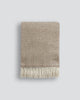 The Baya Littano throw blanket in 'Carob' soft brown colour, folded to show pattern and fringe details