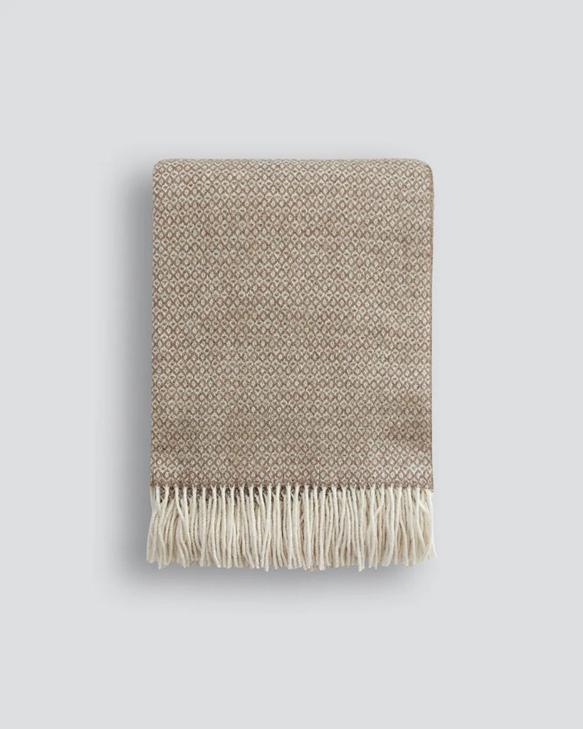 The Baya Littano throw blanket in 'Carob' soft brown colour, folded to show pattern and fringe details