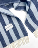 Maison Deux Candy Wrap wool throw in Navy Ice Blue, folded to show the woven brand label and the cream fringe