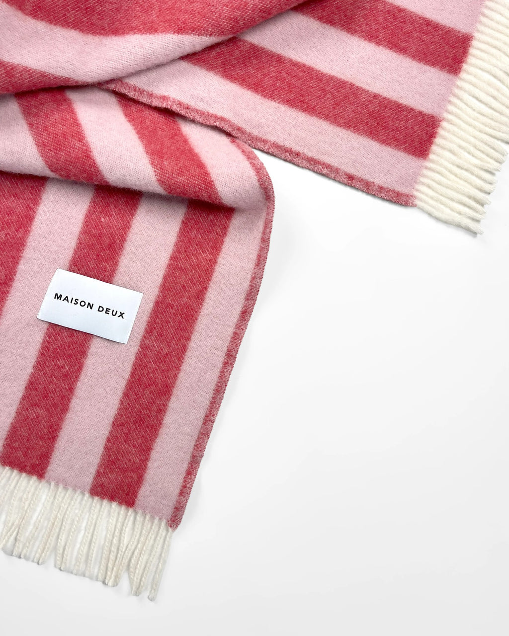 Close-up of the Maison Deux Candy Wrap wool throw in Pink Cherry, showing the woven stripe texture.