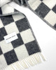 Close-up of the Maison Deux Checkerboard wool throw in Black White, showing the fringed edge and folded corner.