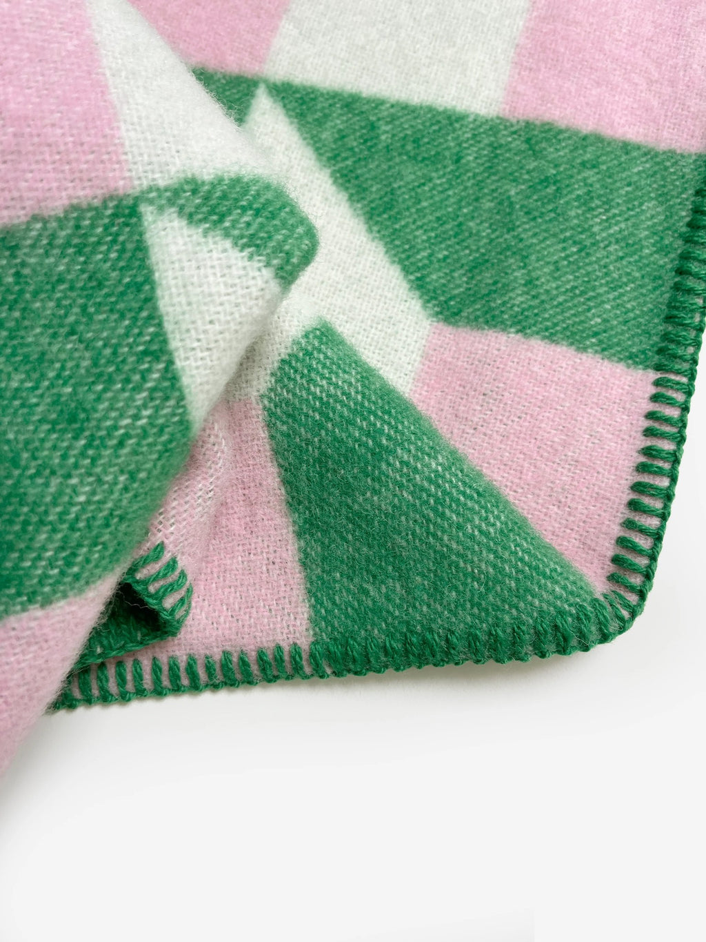 Maison Deux Cubics wool throw in Grass Pink, close up on the jacquard weave and green blanket stitched edge