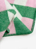 Maison Deux Cubics wool throw in Grass Pink, close up on the jacquard weave and green blanket stitched edge