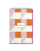 Maison Deux Cubics wool throw in Pink Carrot, folded to show the cube pattern and the woven Maison Deux label
