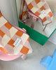 Maison Deux Cubics wool throw in Pink Carrot, draped over a pink stool with a mirror and green wall panel reflected behind it