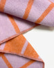 Maison Deux Lines wool throw in Lilac Orange, close-up of the folded fabric showing the diagonal woven pattern.