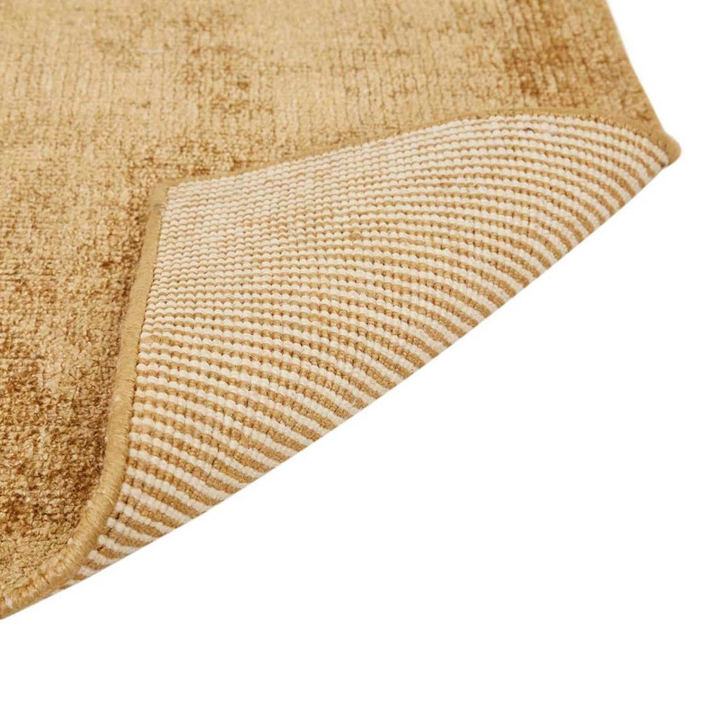 Close up view of the corner of a warm, light honey mustard brown wool blend rug by Globe West and Soren Liv NZ. The edge is flipped up to show the underside of the rug. 