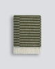 An off-set striped patterned throw blanket in shades of soft sage-green and olive, with a twisted fringe edge in 100% NZ wool by Baya