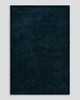 A full image of the Norfolk floor rug in the shade Ink. The border of the rug is cut-pile in a minimalist and refined design, and the pile of the rug's centre is luxuriously deep.
