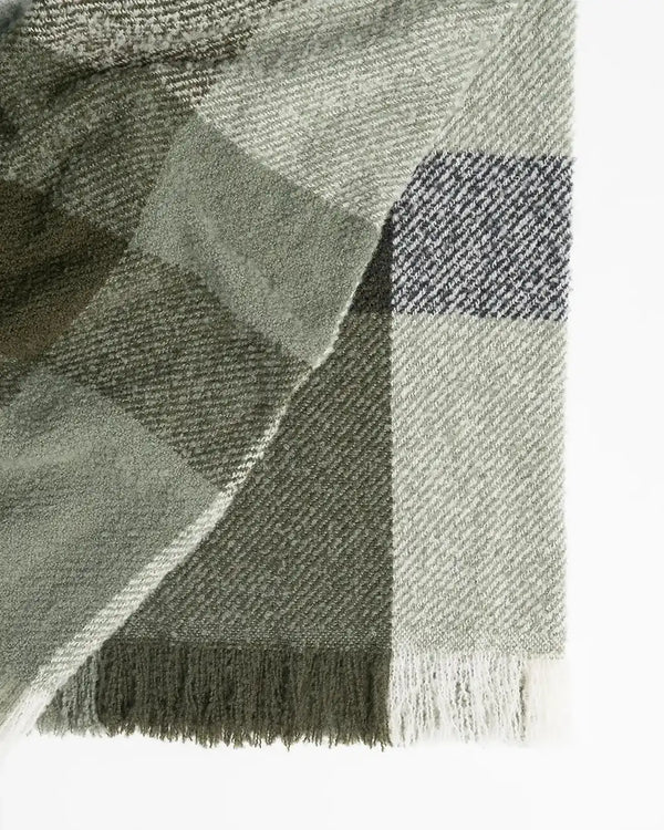 A green plaid boucle NZ-made throw blanket, by Weave Home nz. showing shades of sage green, white and blue