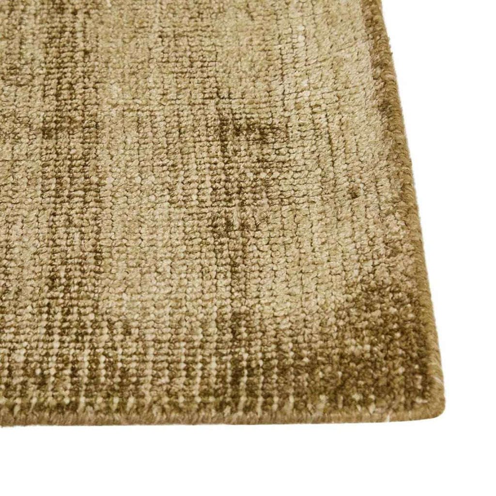 Close up of the corner of a soft, wool blend rug in shades of muted olive green by Soren Liv NZ and Globe West.