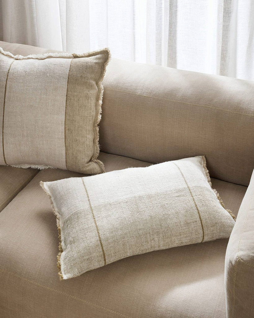 Two soft linen cushions, one in a lumbar shape and one in square, with similar patterns of striped sections in warm beige, contrasting nicely with the cream body of the cushions. By Baya. 