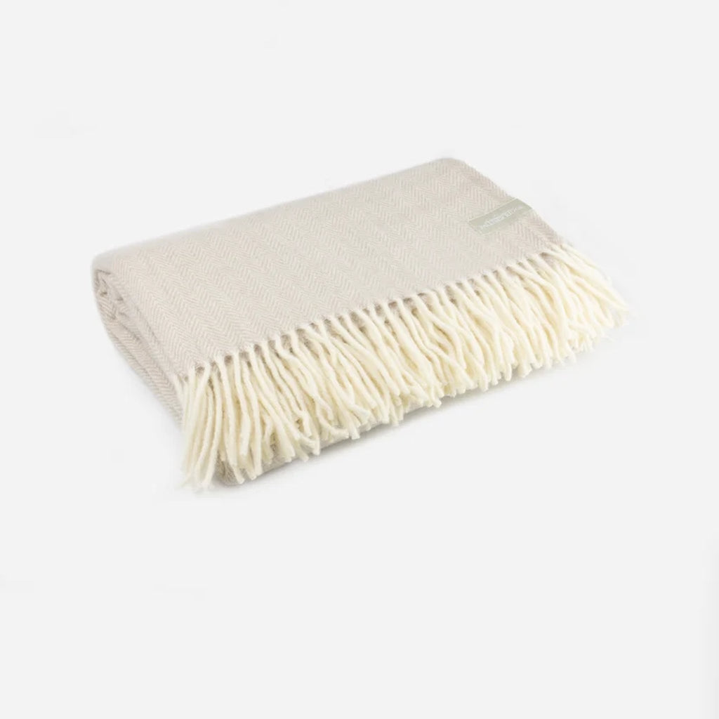 Palliser Ridge Herringbone throw in Fawn folded at an angle, showing the herringbone weave and fringed edge