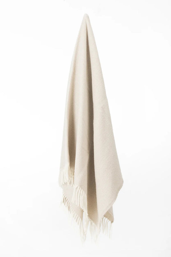 Palliser Ridge Herringbone throw in Fawn hanging in full drape, showing the fringed edge