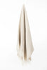 Palliser Ridge Herringbone throw in Fawn hanging in full drape, showing the fringed edge