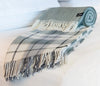 Palliser Ridge Herringbone throw in Forest, rolled and styled on a bed