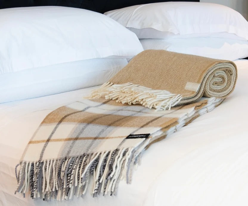 Palliser Ridge Herringbone throw in Mustard, rolled and styled on a bed
