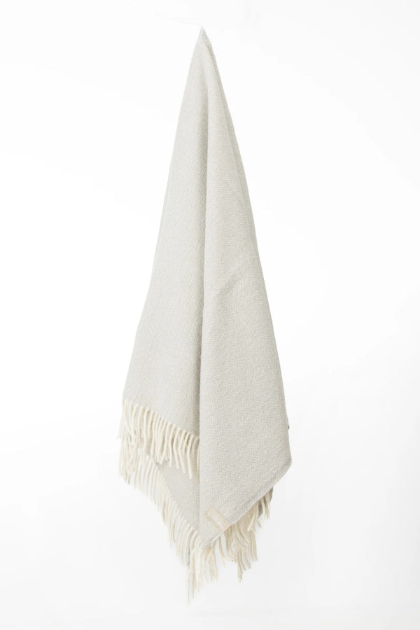Palliser Ridge Herringbone throw in Dove Grey hanging in full drape, showing the fringed edge