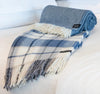 Palliser Ridge Twill Check throw in Royal Blue rolled to show the twill weave, styled on a bed