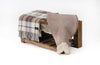 Palliser Ridge Twill Check lambswool throw in Chocolate, folded and draped on a wooden bench with another folded throw alongside