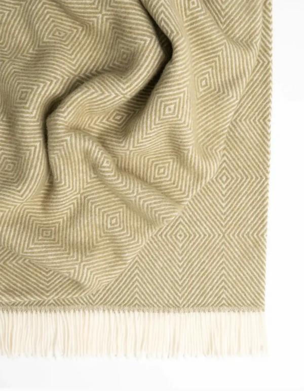 A soft pea-green NZ wool throw blanket in a traditional Scandinavian design, by Weave Home nz