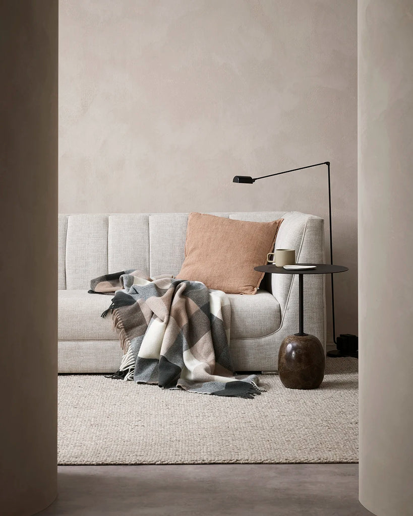 Nz made wool throw blanket in a modern plaid featuring blush browns, black and cream, in a contemporary lounge room