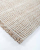 The Rhodes outdoor rug in teak and cream tones, seen close up at the corner showing the stylish weave
