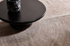 A wool blend rug featuring a circle geometric design, seen under a table