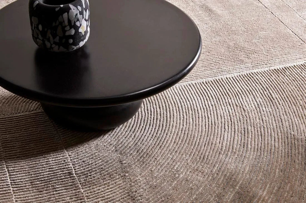 A wool blend rug featuring a circle geometric design, seen under a table