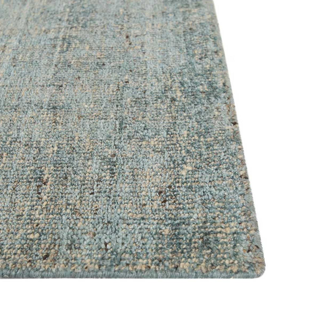 Close up of the corner of a viscose blend statement rug in shades of muted ocean blue, by Globe West and Soren Liv NZ.