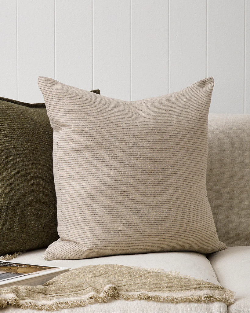 The Baya linen khaki pinstripe cushion next to a contrast green cushion