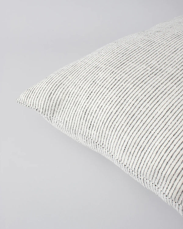 Close up of the Baya Sandridge cushion in creamy white with a fine pin stripe