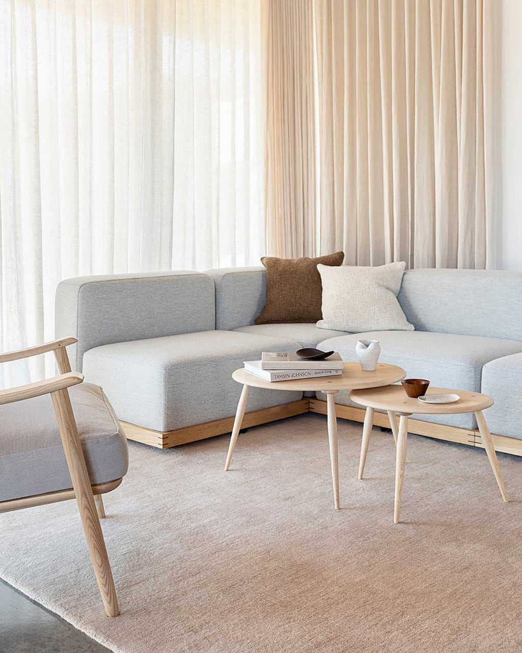 A blush pink floor rug in 100% wool in a modern, sophisticated living room. 