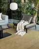 A chic modern lounge with leather chairs and a light green-yellow floor rug. 
