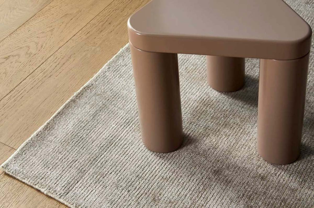 A soft, muted silver floor rug made with a wool blend, by Soren Liv NZ and Globe West, situated under a modern designer coffee table.
