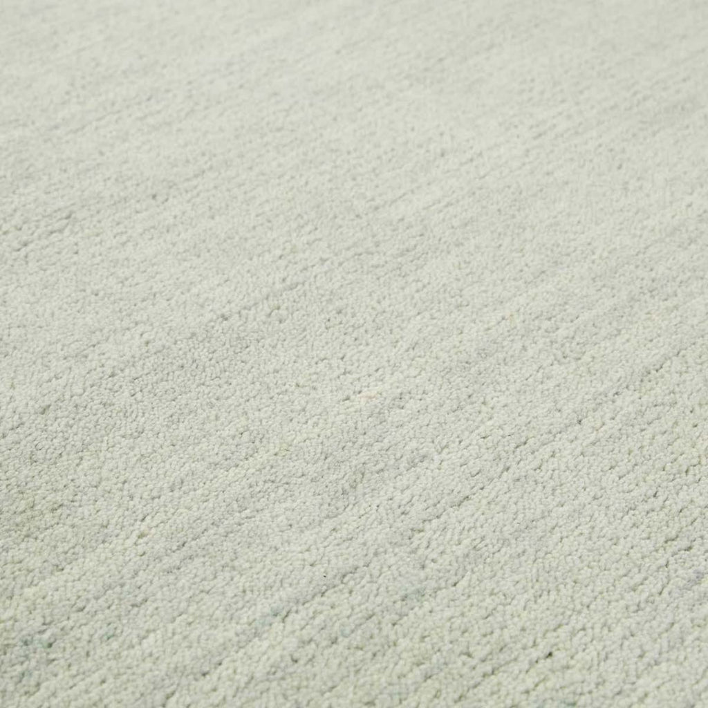 Close up of the weave of a handmade, 100% wool floor rug by Soren Liv NZ and Globe West, in subtle shades of light blue and green, shades of seafoam. 