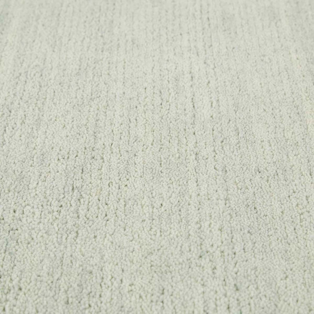 Close up of the weave of a handmade, 100% wool floor rug by Soren Liv NZ and Globe West, in subtle shades of light blue and green, shades of seafoam. 