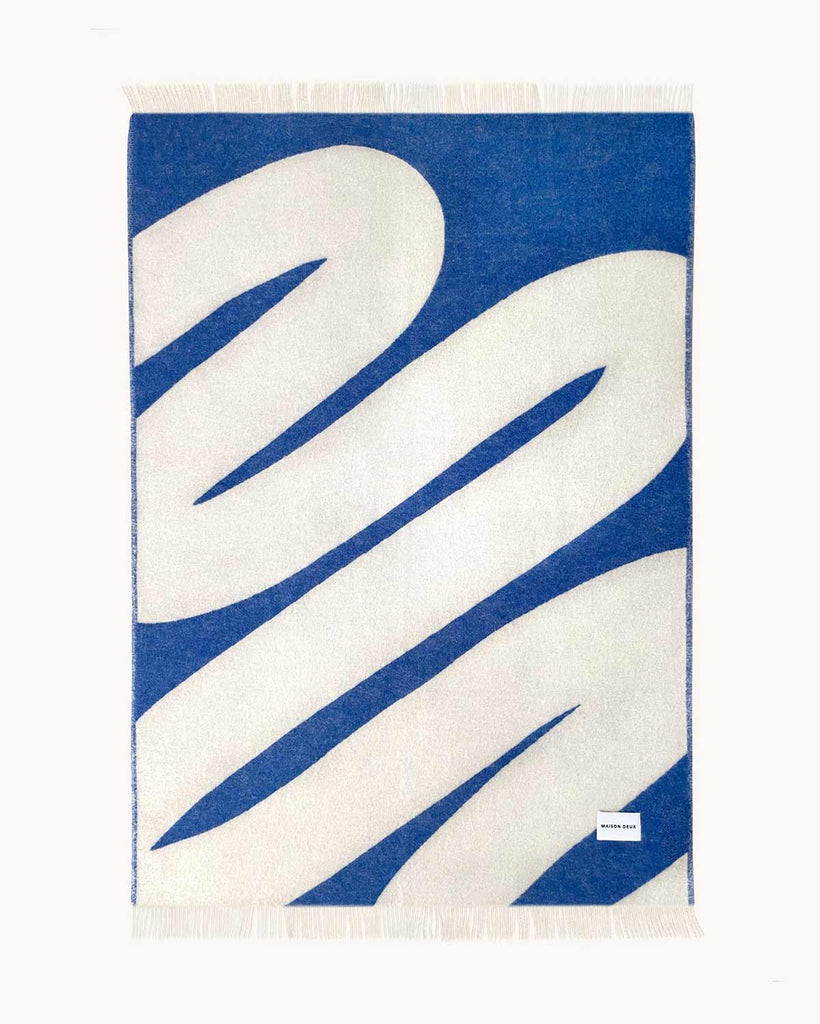Full view of the reversed Swirl patterned throw in shade Cobalt White by Maison Deux