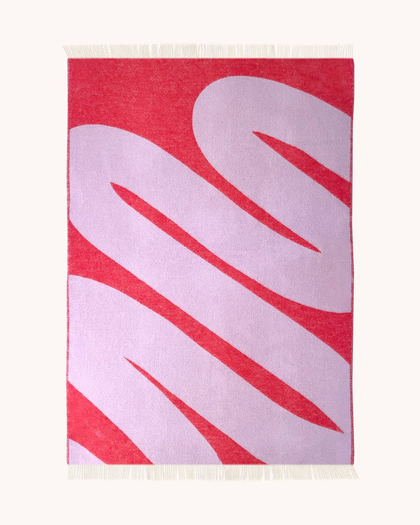 Full view of the Swirl patterned throw in shade Scarlet Lilac by Maison Deux