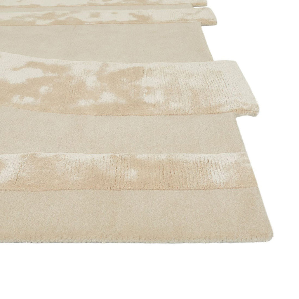 Corner view of a cream, light natural beige floor rug with geometric designs rendered in alternating pile heights, by Globe West and Soren Liv NZ.