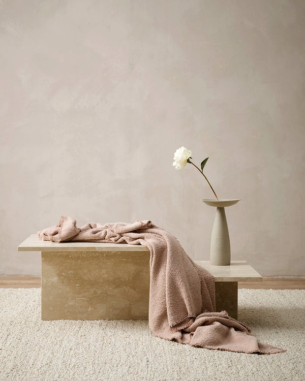 The Baya 'Cromwell Blush' throw blanket draped on a table in a contemporary living room